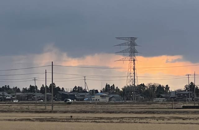 燕市から夕焼け空がのぞっき雲の下に雨がしま模様のように見える