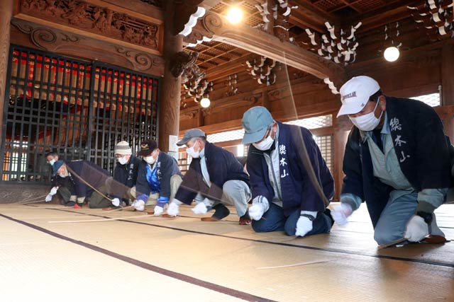 本堂の畳の目に詰まったほこりをタケの棒でたたき出す