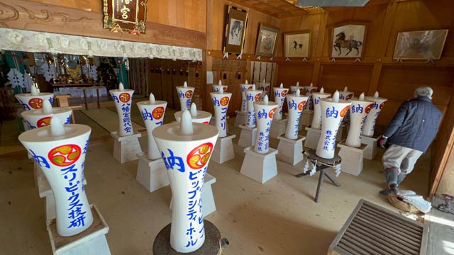 夜は献灯祭で火をともす和ろうそくが並ぶ八幡宮拝殿