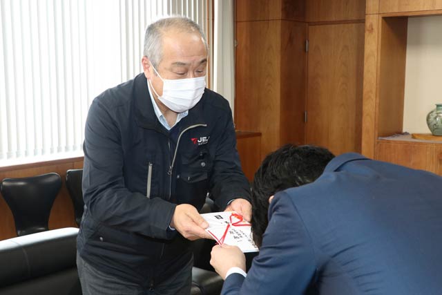 滝沢市長に寄付の目録を手渡すJEJアステージの原社長