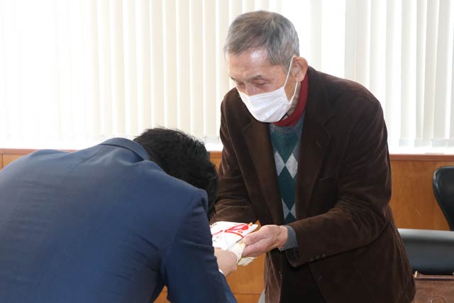 滝沢亮市長に寄付を手渡す梨本さん