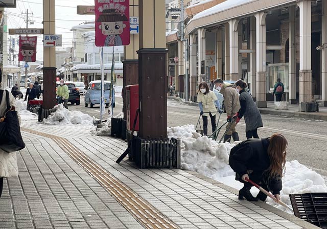 上越市の商店街で流雪溝に雪を流す作業