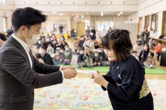 三条市に寄付し「あそぼって」に設置した幼児用滑り台の寄付の目録を滝沢三条市長に手渡す佐藤ひらりさん