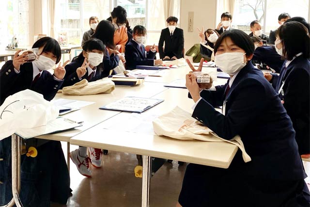卒業式を終え、最後の学活で祝菓を受け取った児童