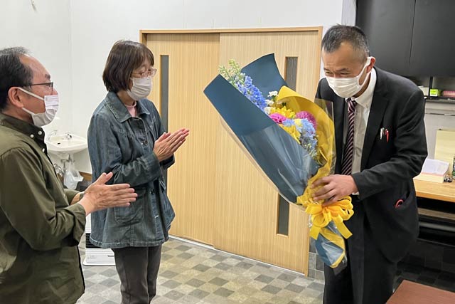 選挙事務所で支援者から花束を受け取る更科氏