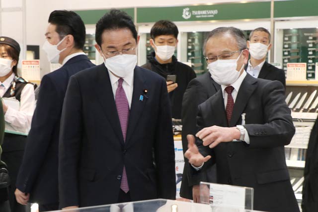 燕三条地場産業振興センターの物産館を見学する岸田首相(左)と案内する佐藤専務理事(右)