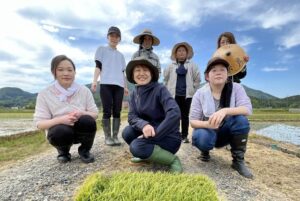 弥彦温泉キャラクターの酒造り目指しおかみが手で田植え
