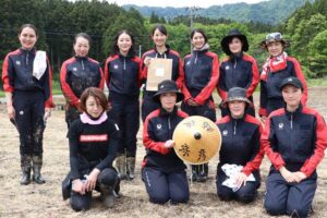 田植えを終わって記念写真を撮影する日本航空のキャビンアテンダント