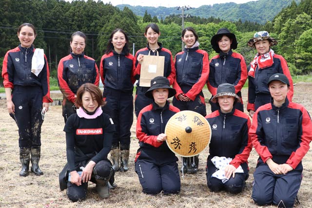田植えを終わって記念写真を撮影する日本航空のキャビンアテンダント