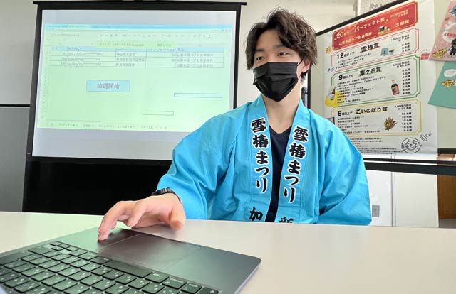 抽選開始ボタンをクリックするは雪椿まつりアンバサダーで地域おこし協力隊の松本悠雅さん