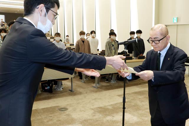 奨学生代表に奨学生認定証を手渡す高波さん