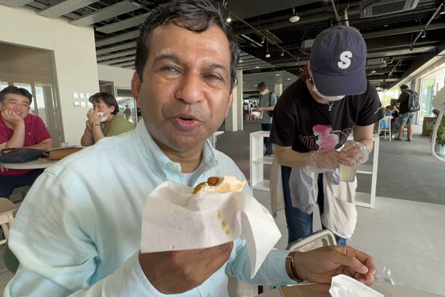 自身のレシピを学生に伝授して模擬店で販売された「シャハカレー」を味わうシャハリアル学長が