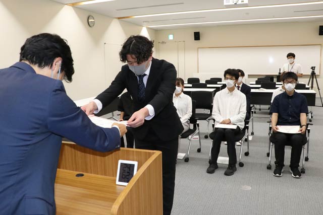 奨学生認定証を手渡す