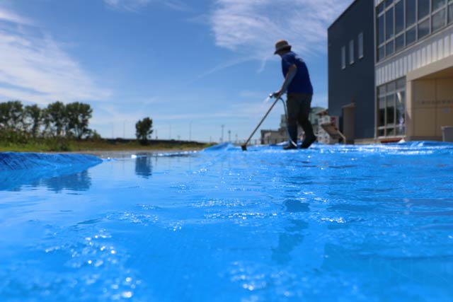 ブルーシートを水洗いする三条市水防学習館の職員
