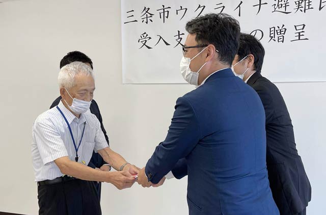 上石会長に寄付を手渡す