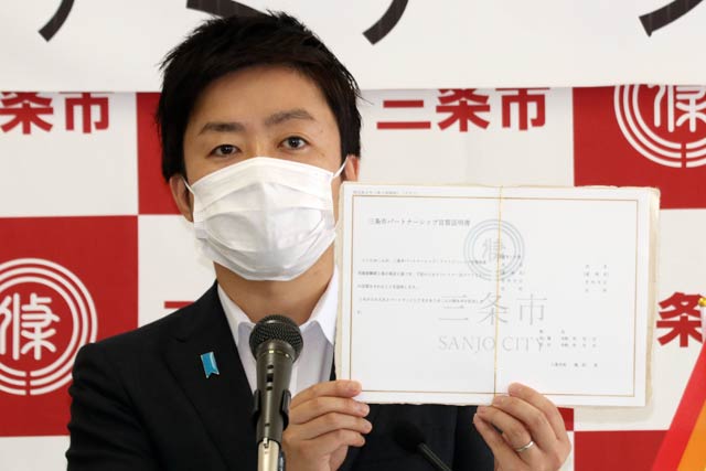 三条市パートナーシップ宣誓証明書のサンプルを示す滝沢市長