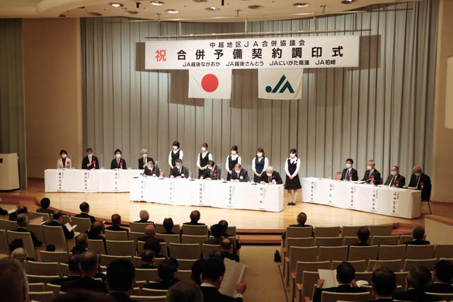 合併予備契約調印式で契約書に調印