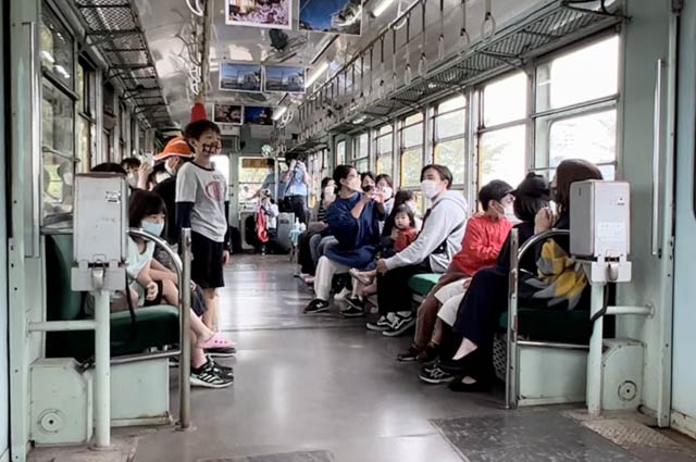 走るかぼちゃ電車の車窓の景色を眺める参加者