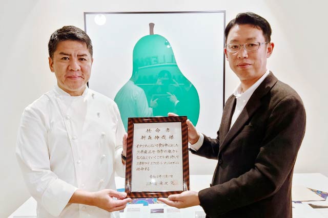 滝沢亮三条市長の代理の「しただ米市場拡大推進協議会」の藤家委員(右)から三条市フードエクスポートアンバサダーの任命書を受ける新森伸哉シェフ