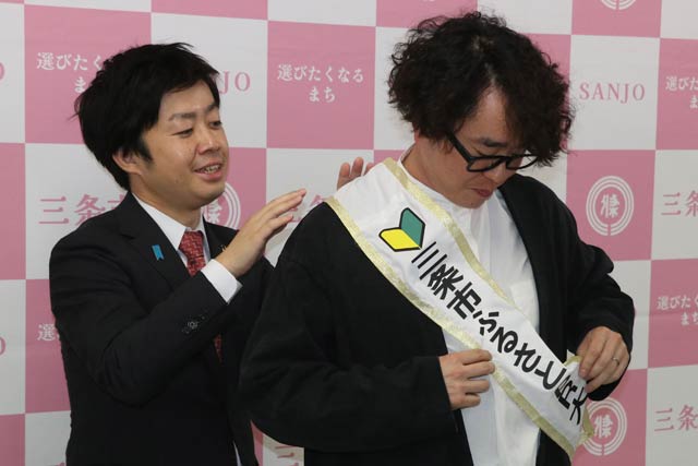 関田さんにたすきをかける滝沢市長