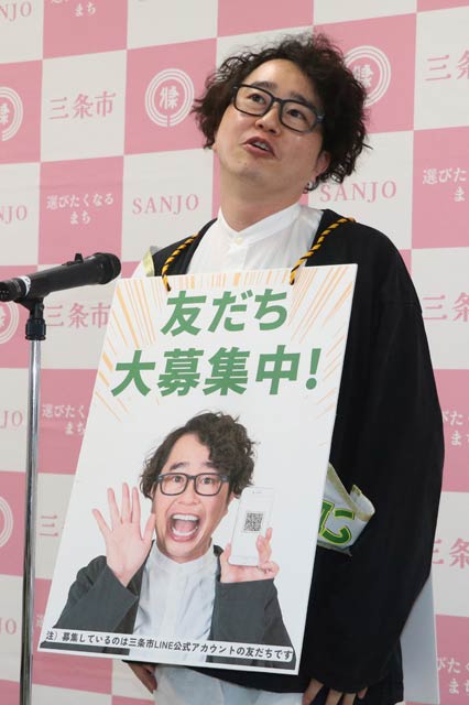 三条市の公式LINEアカウントのPR看板を下げた関田さん