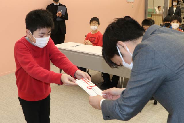 5年生代表から滝沢市長に寄付を手渡す