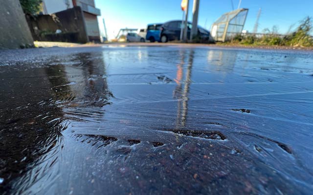 氷が張って鏡のようになった道路