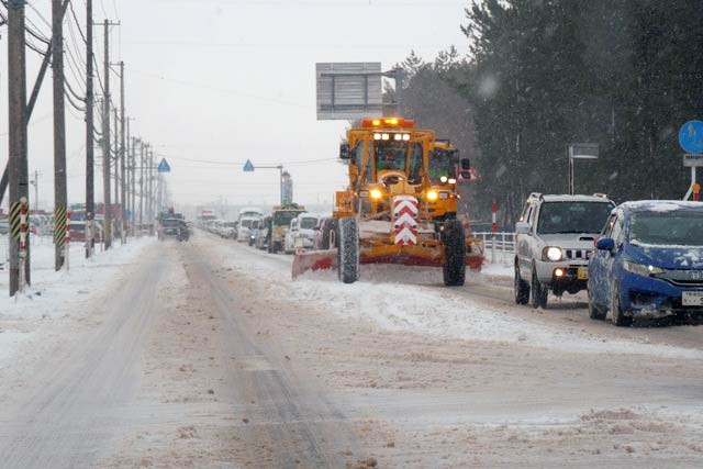 国道116号の除雪で26日午前8時ちょうどの燕市・下粟生津交差点を走る除雪車