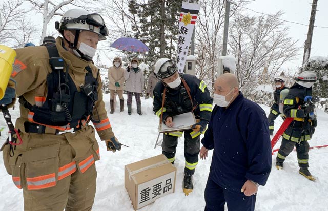 三条市消防本部職員に火災の状況を説明する伝住職