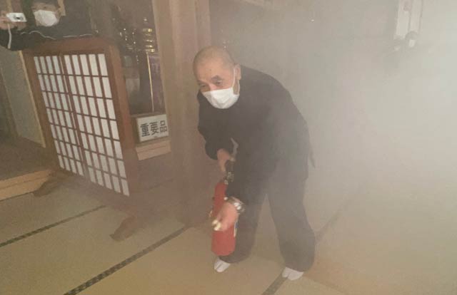本堂で初期消火を行う伝住職