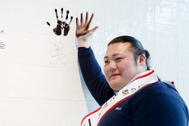 壁に手形を押してサイン