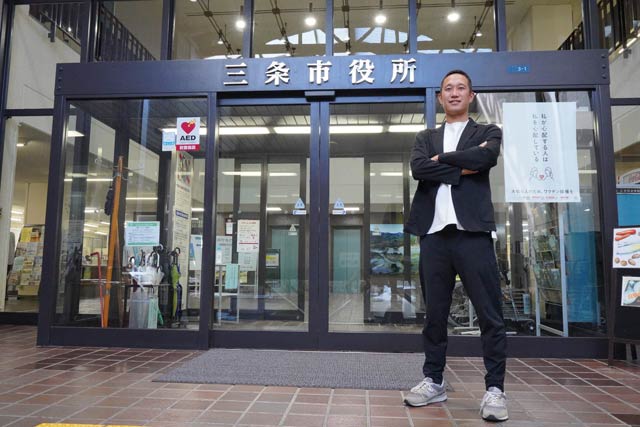 三条市役所正面玄関前で澤CMO