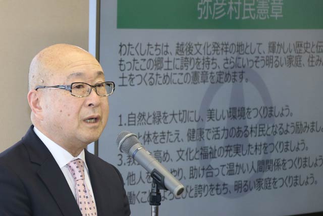 訓示する本間村長のとなりのモニターに村民憲章