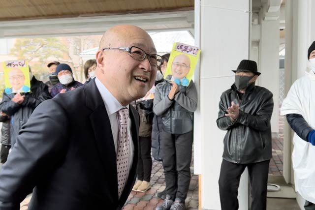 役場前で支持者に迎えられる本間村長