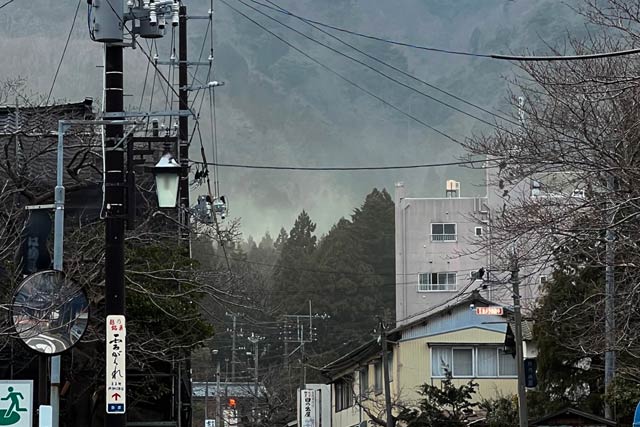 弥彦山ふもとの煙か霧のように見えるスギ花粉の飛散
