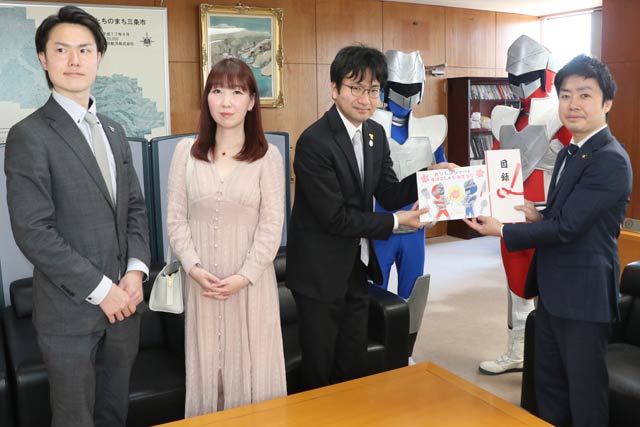 滝沢市長に絵本を手渡す