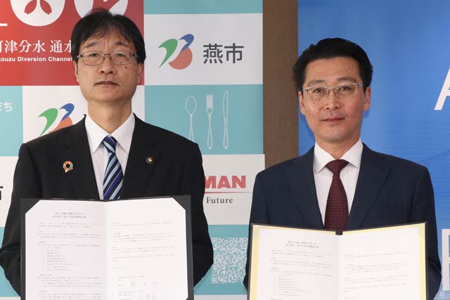 調印した協定書を手に鈴木燕市長(左)と北越工業の佐藤取締役管理本部長