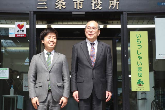 正面玄関で滝沢市長と並んで記念撮影