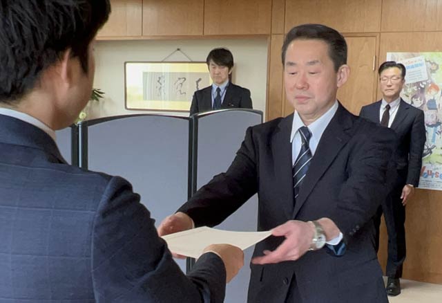 滝沢市長から高橋教育長に辞令を手渡す