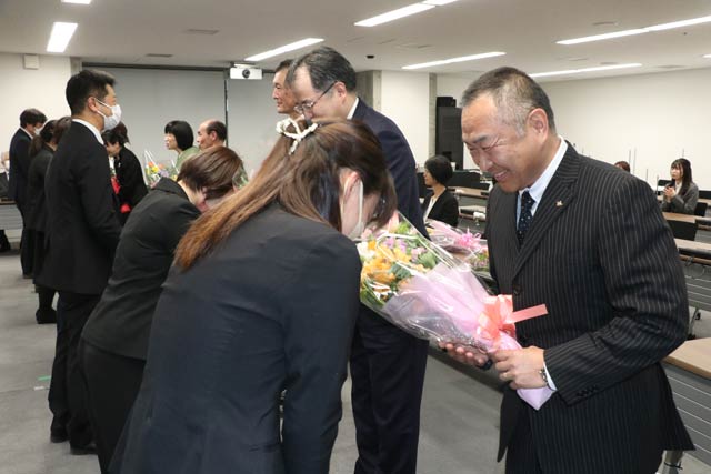 退職者に後輩から花束を手渡す