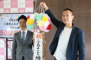 くす玉を割る滝沢市長(左)と澤CMO