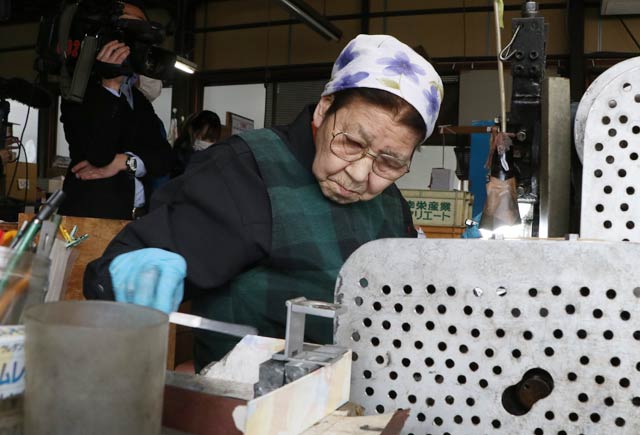 目立て機に向かう作業中の岡部さん