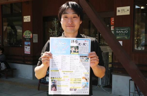 ポスターを手に来場を呼びかける駅長の中野貴文さん