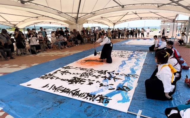 大勢の人が書道パフォーマンスを見学