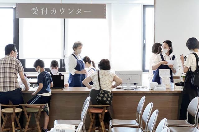受付カウンターでスタッフが忙しく