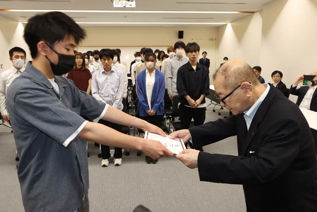 奨学生代表に小学生認定証を手渡す高波さん