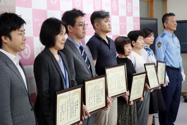 感謝状を受けた金融機関職員と来店客