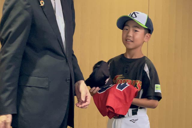 鈴木市長からユニホームとキャップを受け取った涌井主将