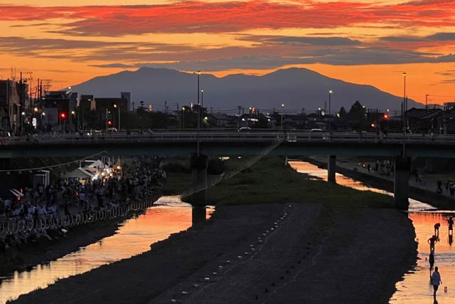 夕焼けに染まる越後加茂川夏祭りの舞台の加茂川