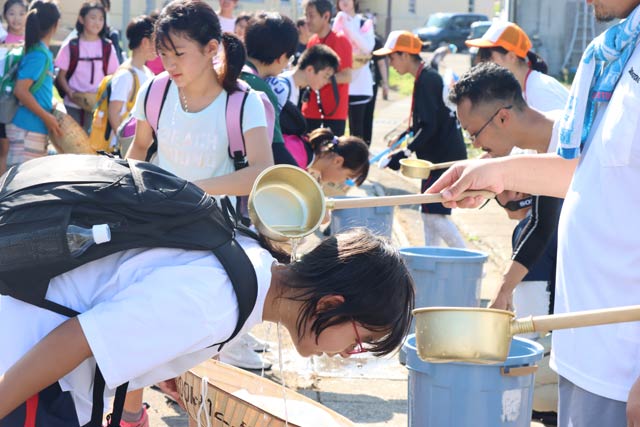 最初の休憩ポイントの旧荒沢小学校で水かけ